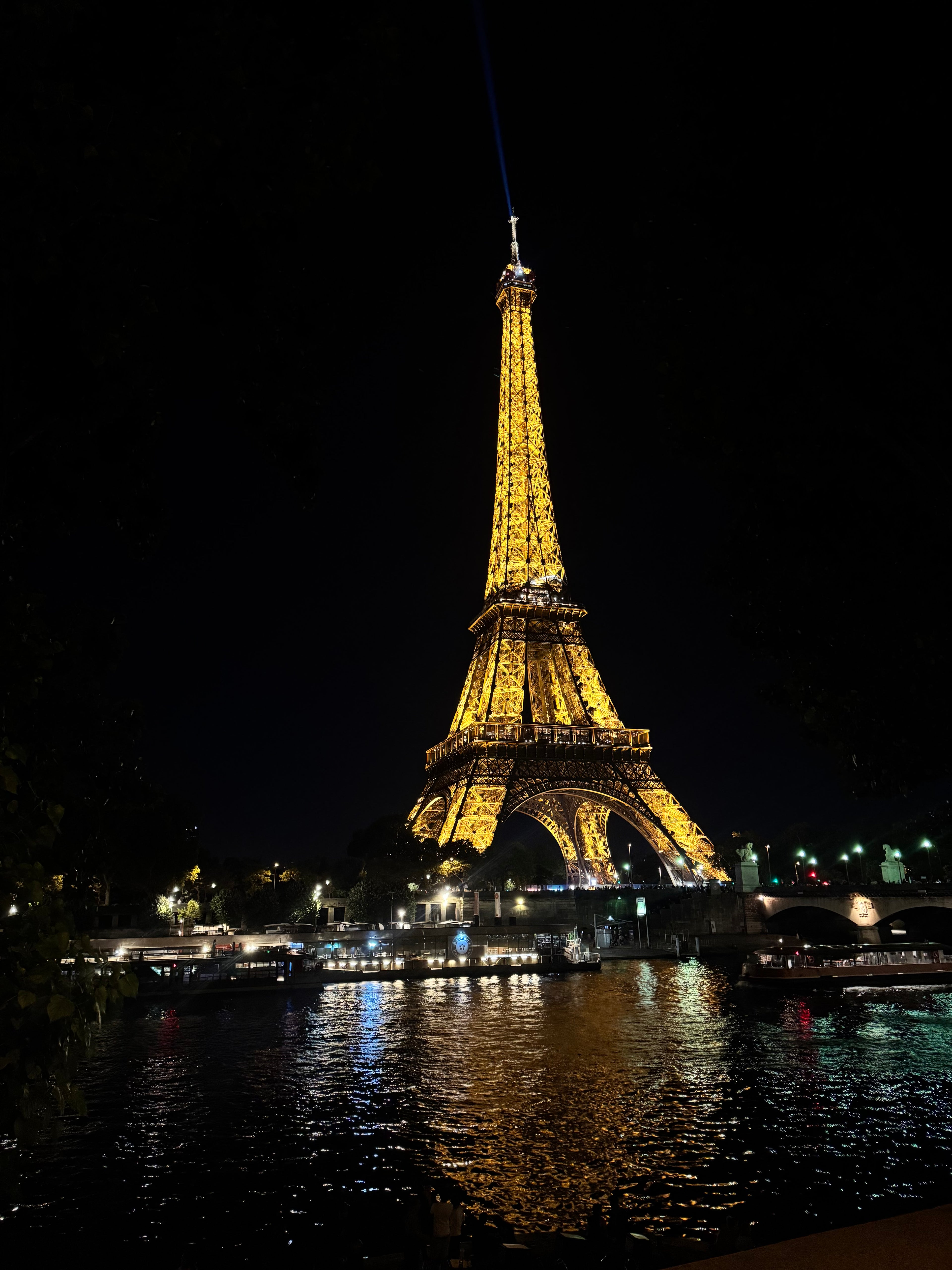 Eiffel Tower illuminated at night with reflections on the water